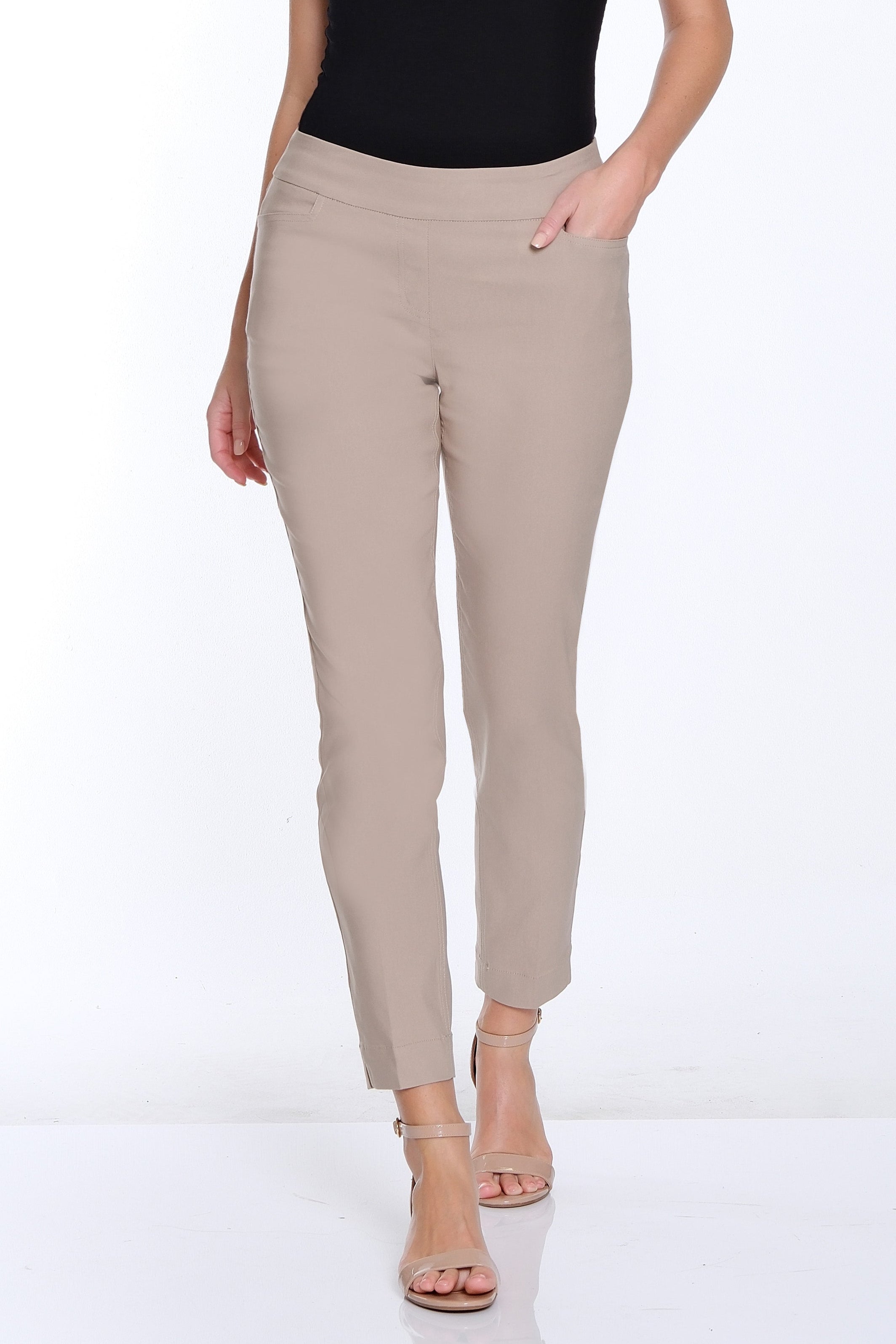 Woman wearing a black top and beige pants on a white background