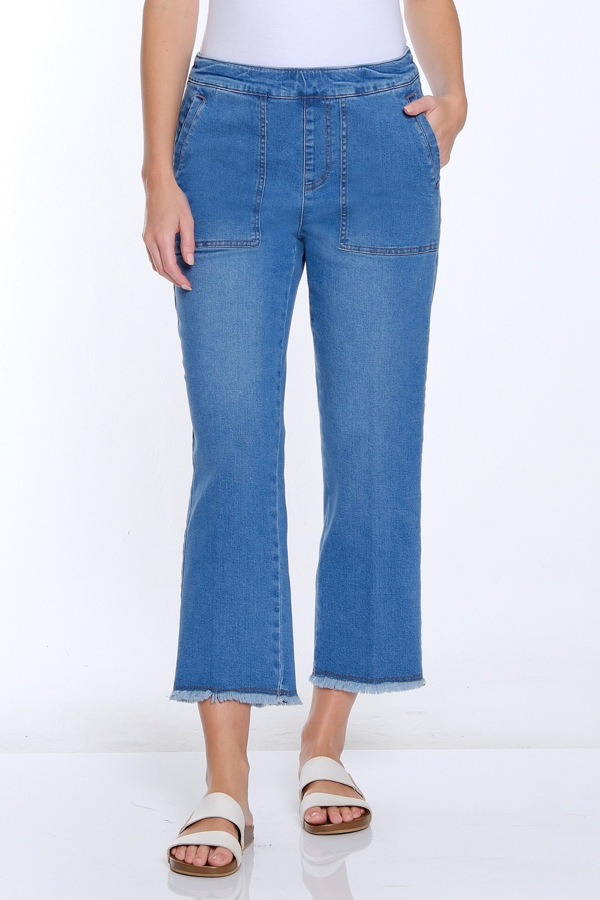 Woman wearing a white t-shirt and blue jeans on a white background