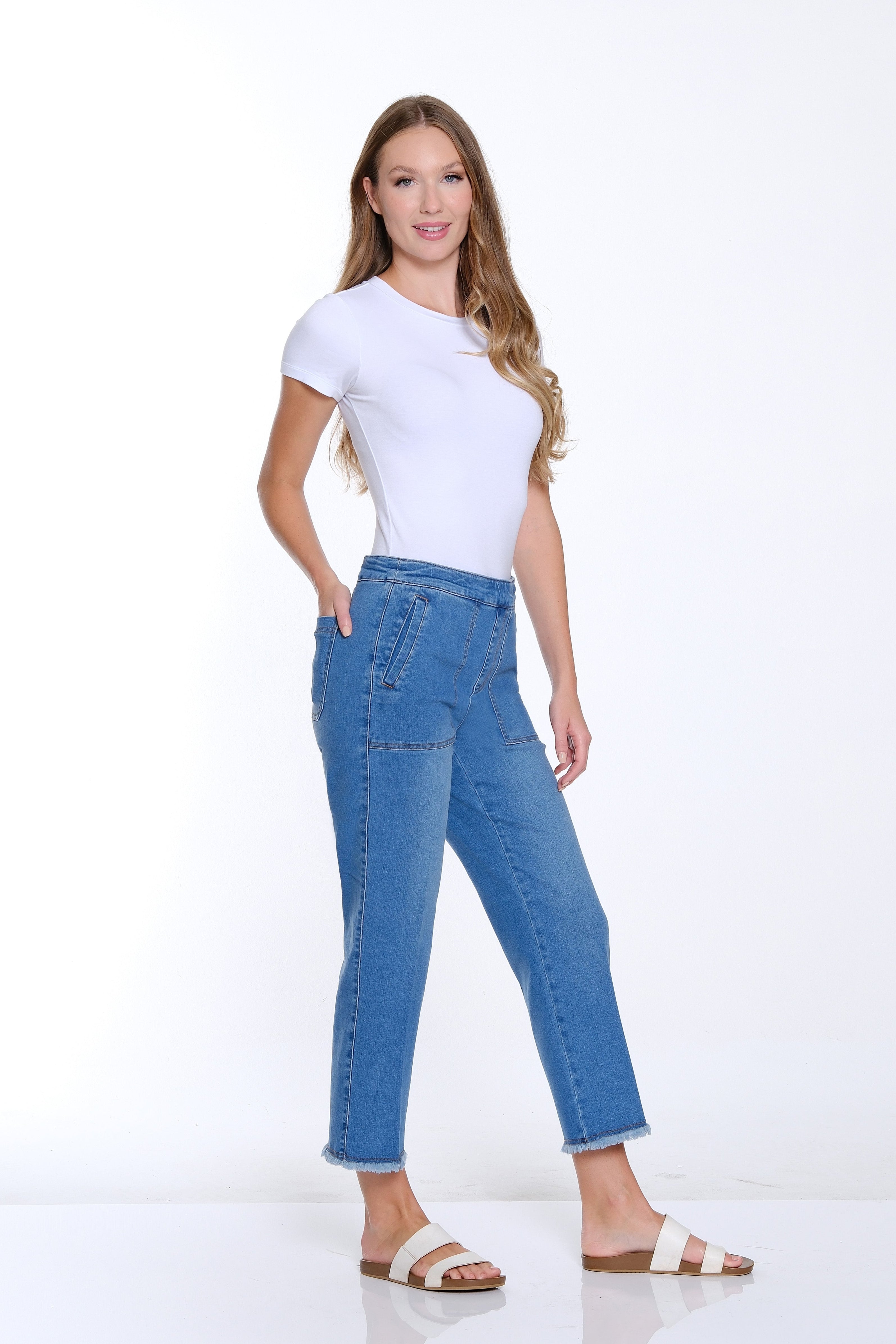 Woman wearing a white t-shirt and blue jeans on a white background