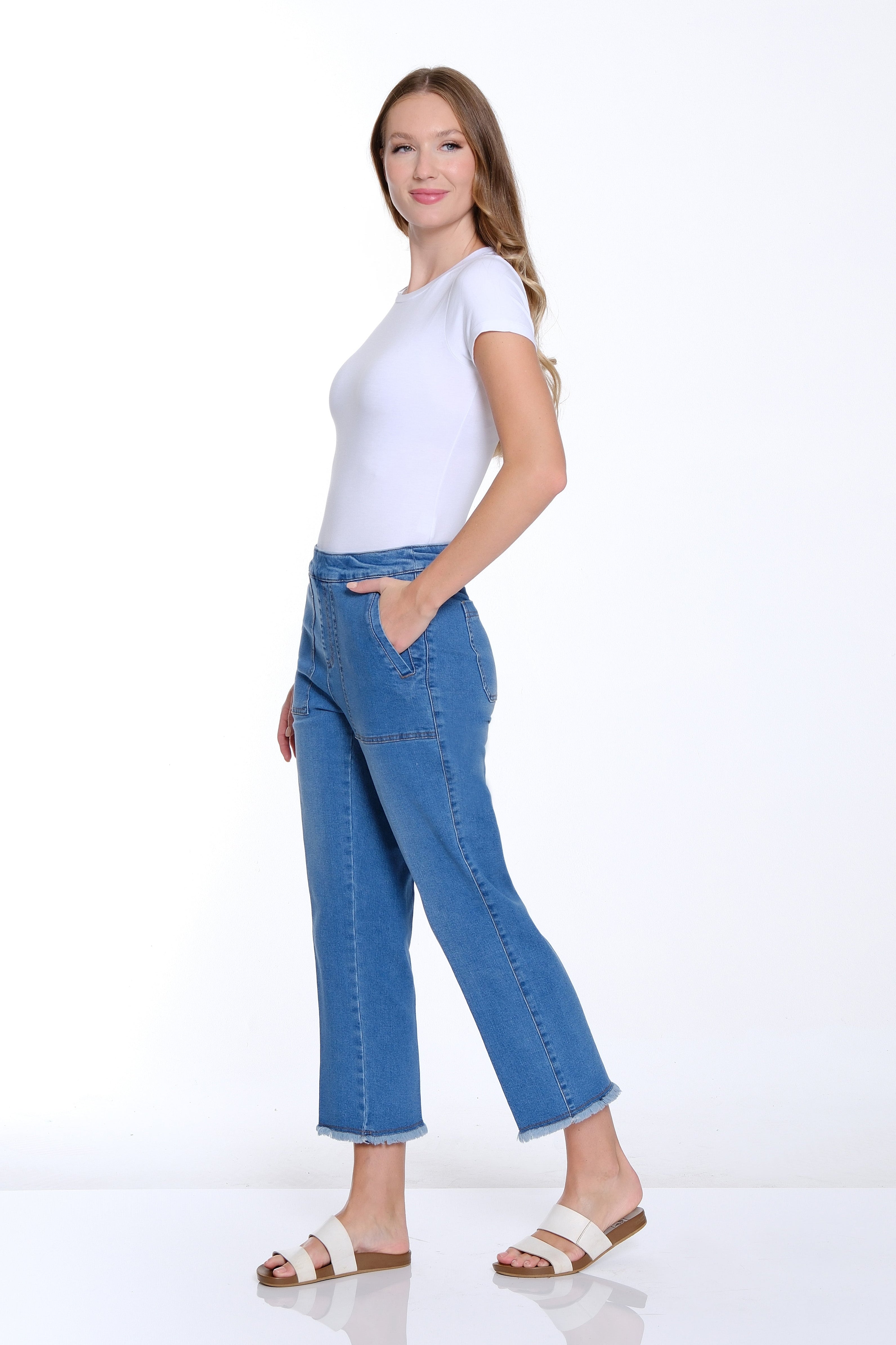 Woman wearing a white t-shirt and blue jeans on a white background