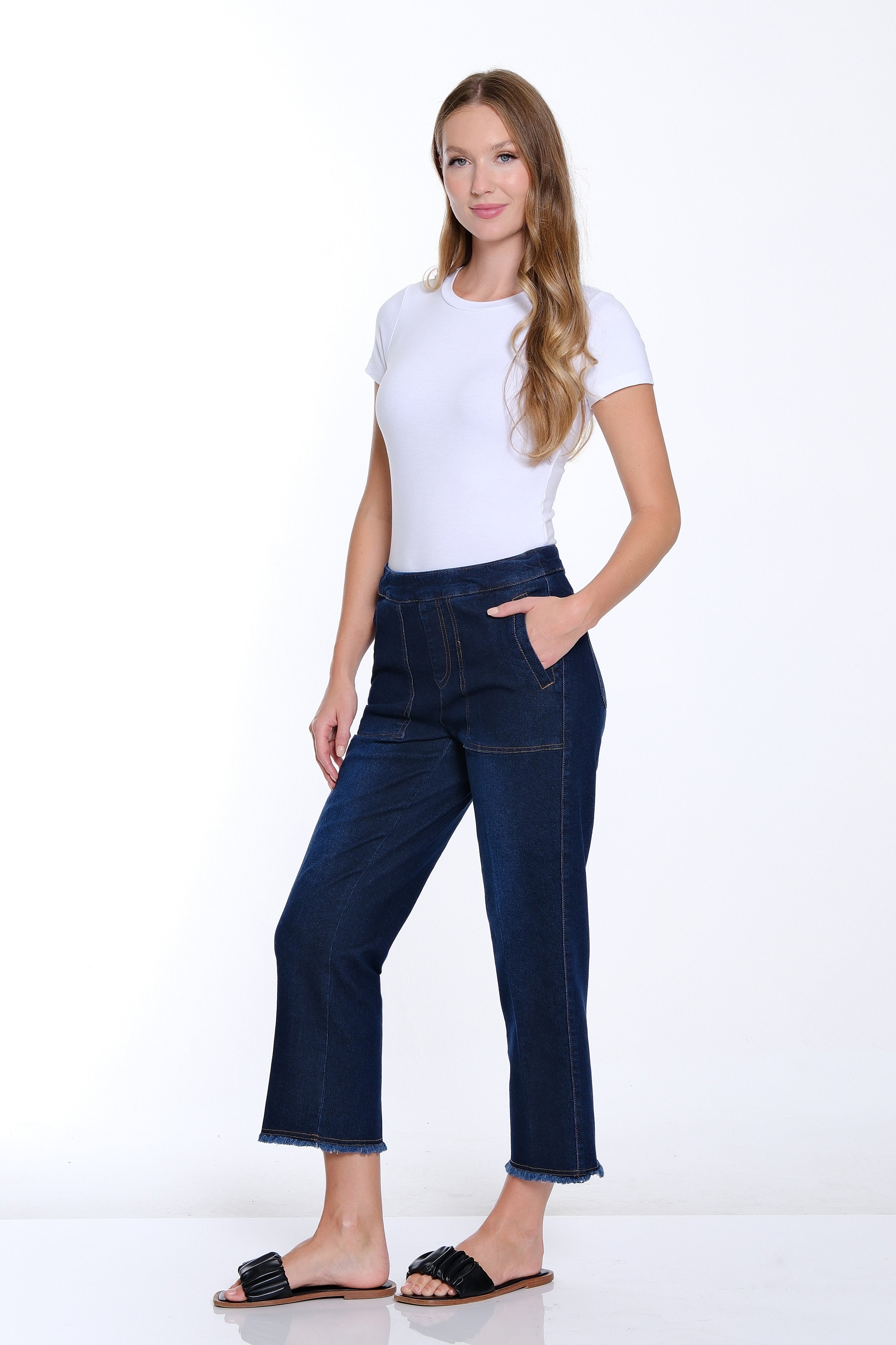 Woman wearing a white t-shirt and dark blue jeans on a white background