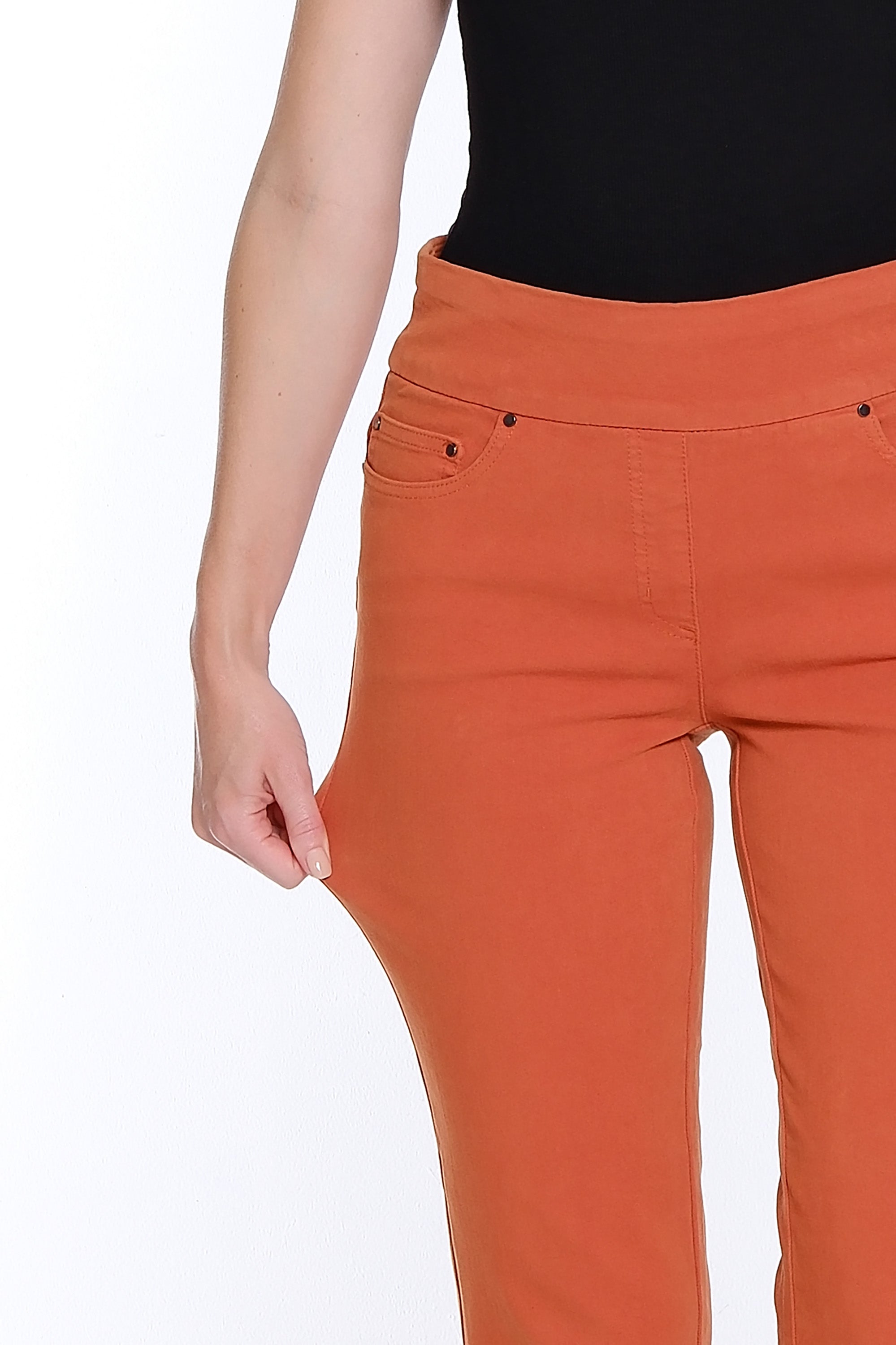Orange pants worn by a person on a white background