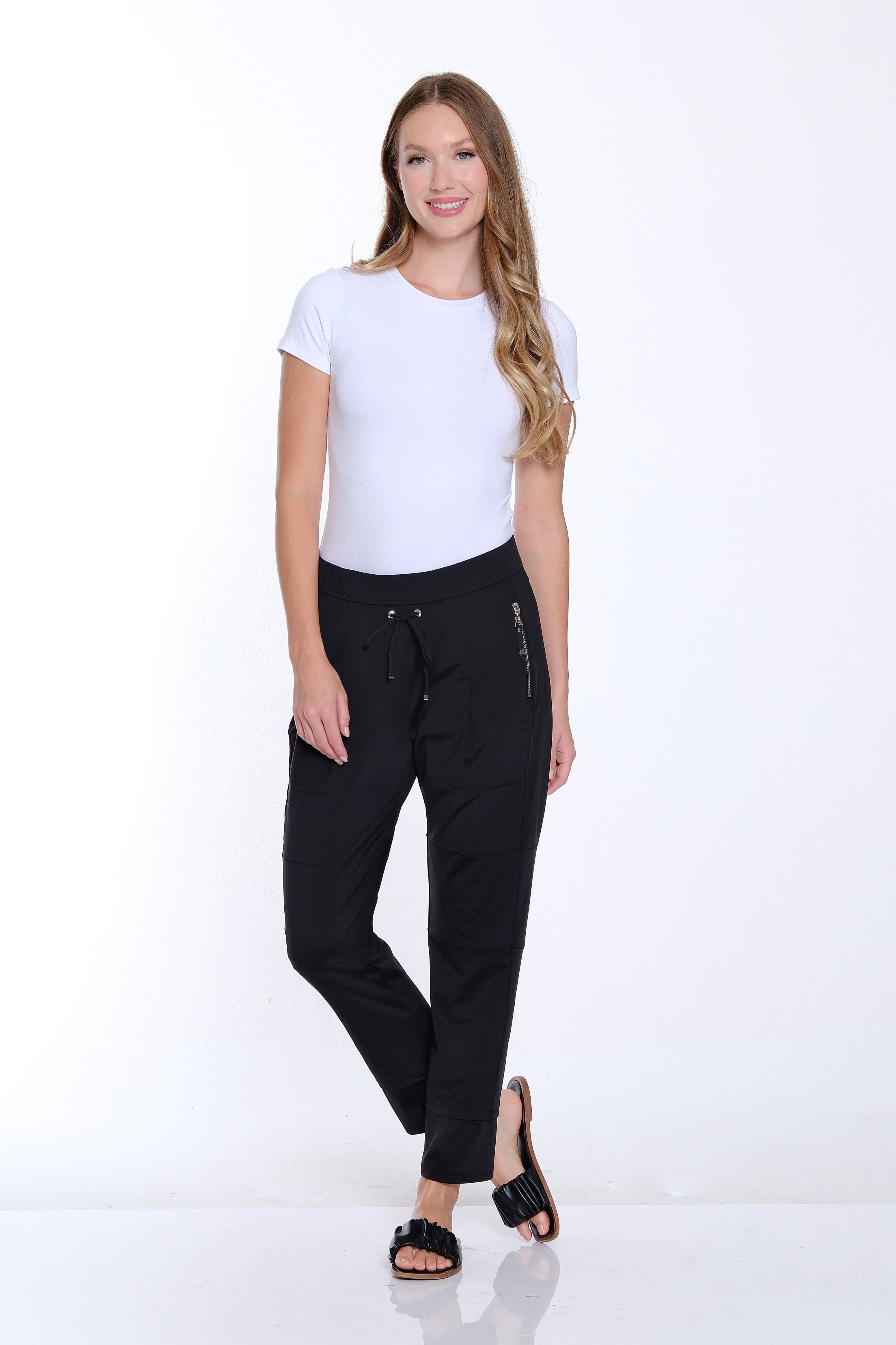 Woman wearing a white top and black pants on a white background