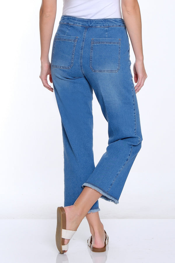 Woman wearing blue jeans and a white top on a white background