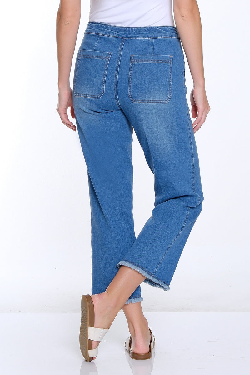 Woman wearing blue jeans and a white top on a white background