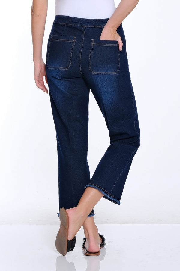Woman wearing blue jeans and a white top on a white background