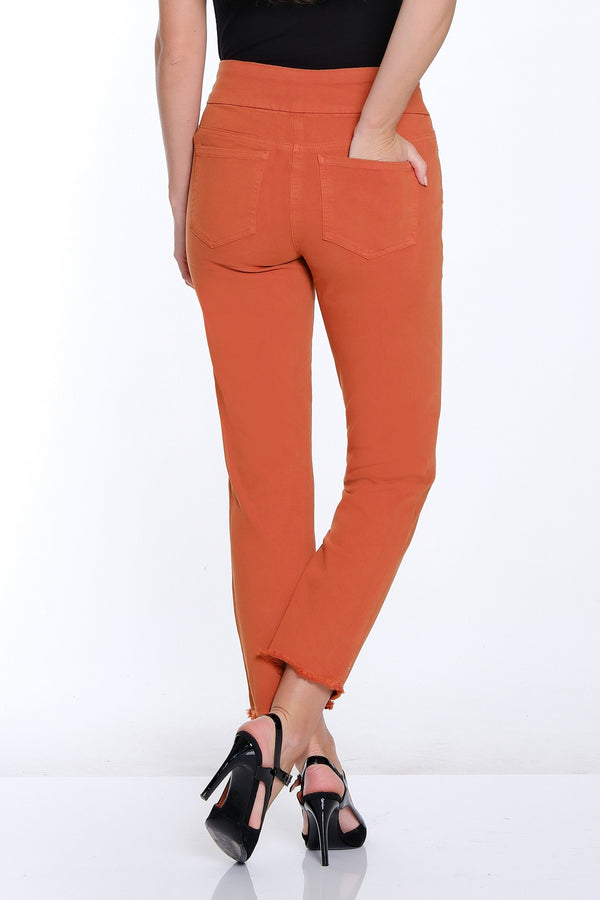 Woman wearing orange pants and black top on a white background