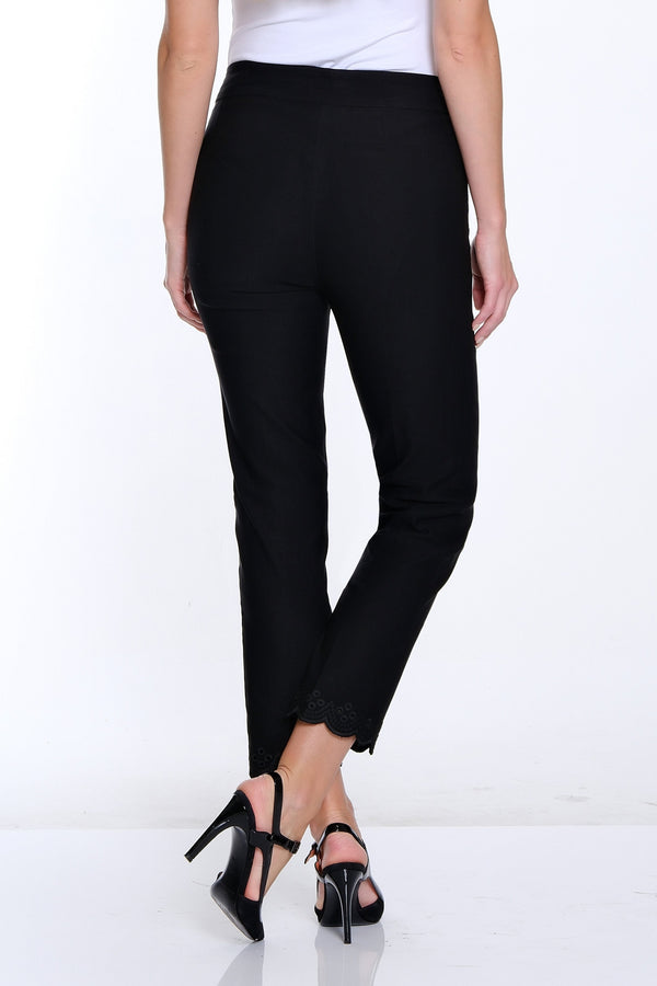 Woman wearing a white top and black pants on a white background