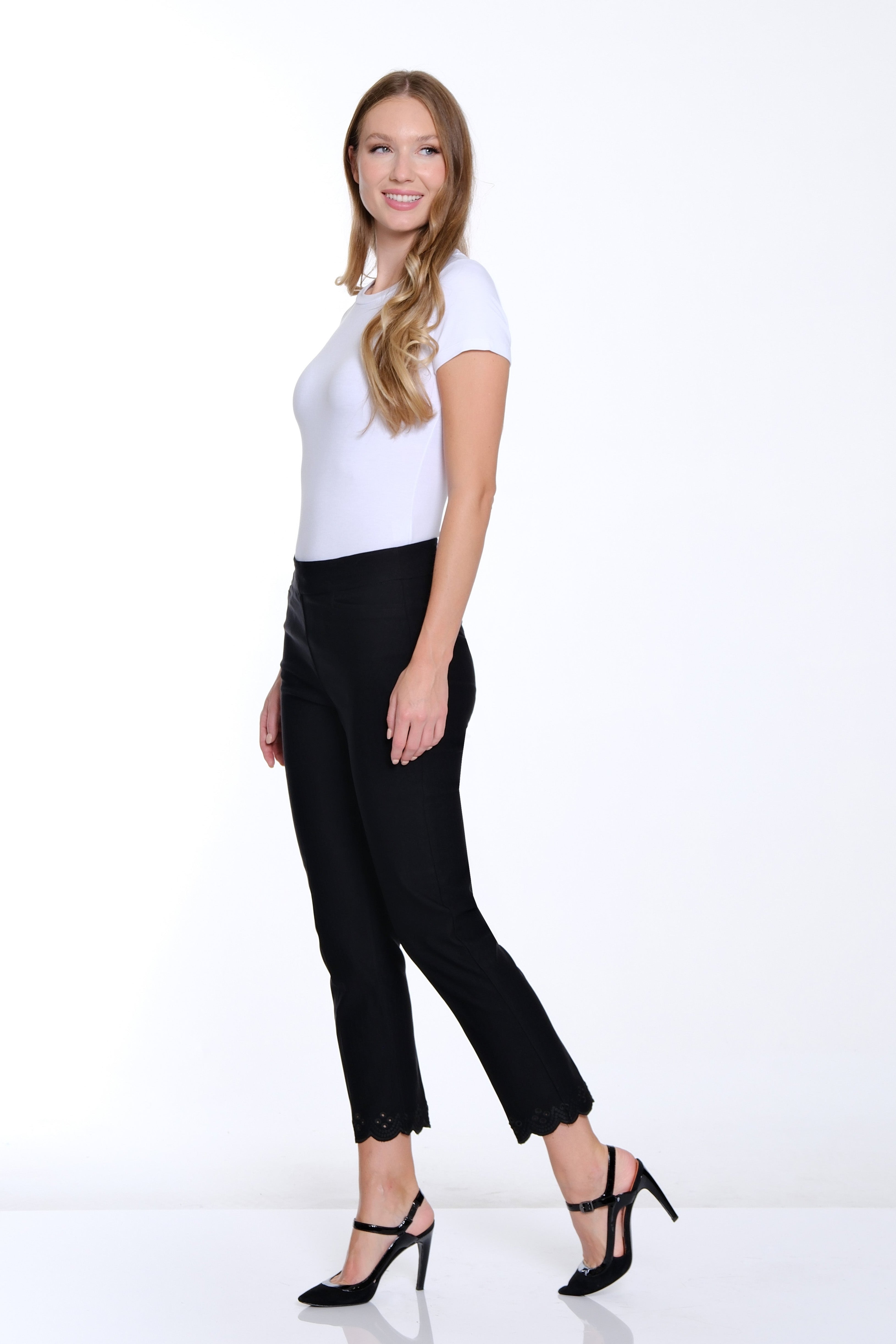 Woman wearing a white top and black pants on a white background